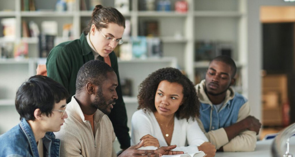 Groupe d'étudiants en formation professionnelle échangeant autour d'un projet de groupe.