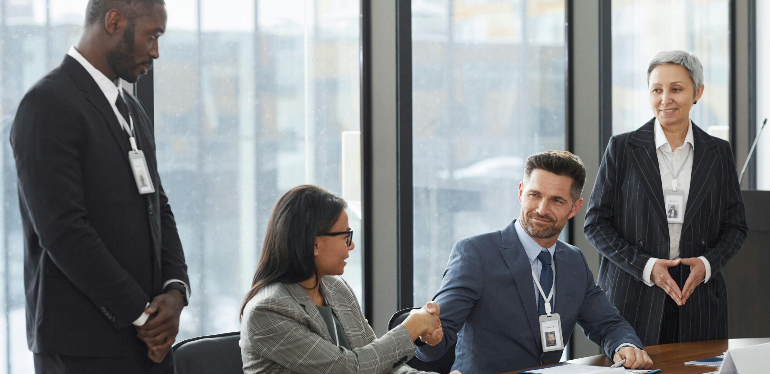 Réunion d'entreprise avec poignée de main formalisant un accord ou une élection.